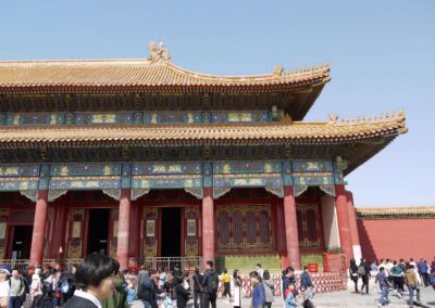Pictured is the Forbidden City, an ancient building, and its roof tiles. In the foreground are tourists milling about.