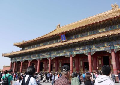 Pictured is the Forbidden City, an ancient building, and its roof tiles. In the foreground are tourists milling about.